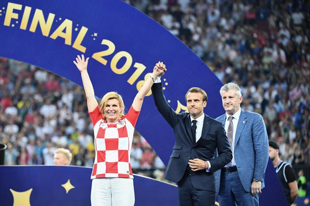 French President Emmanuel Macron (C) and Croatian President Kolinda Grabar-Kitarovic acknowledge the public after the Russia 2018 World Cup final football match between France and Croatia at the Luzhniki Stadium in Moscow.(AFP)