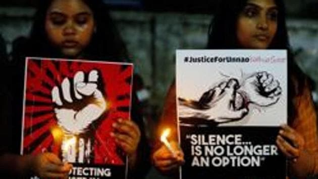 Women hold candles and placards during a protest against two rape cases, in Ahmadabad, on April 16, 2018. (AP File) Women hold candles and placards during a protest against two rape cases, in Ahmadabad, on April 16, 2018. (AP File)