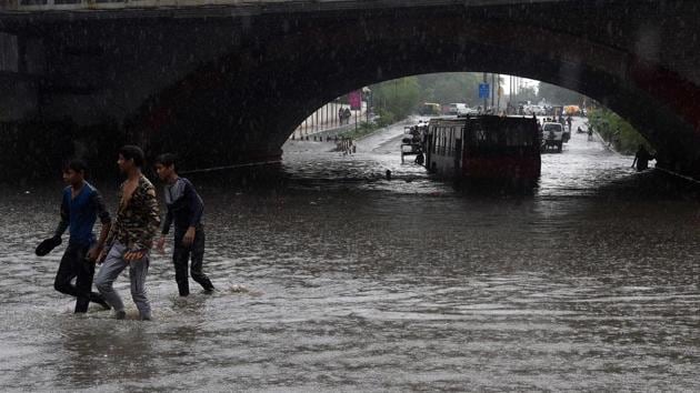 A bus is seen submerged under Minto bridge as Indian youths walk along a water-logged road during heavy monsoon rain in New Delhi on July 16. (AFP Photo) A bus is seen submerged under Minto bridge as Indian youths walk along a water-logged road during heavy monsoon rain in New Delhi on July 16. (AFP Photo)