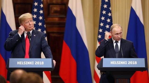 U.S. President Donald Trump, left, Vladimir Putin, Russia's President, adjust their earpieces during a news conference in Helsinki, Finland, on Monday, July 16, 2018.(Bloomberg)