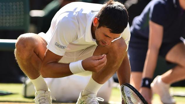 Serbia's Novak Djokovic eats some grass from the court as he celebrates after beating South Africa's Kevin Anderson 6-2, 6-2, 7-6 in their men's singles final match.(AFP)