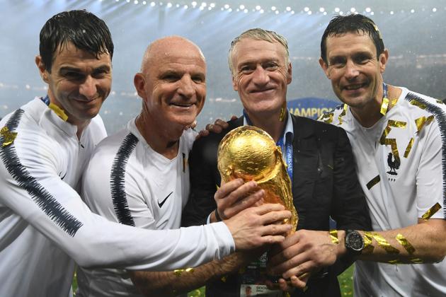 France's coach Didier Deschamps (2R) and France's assistant coach Guy Stephan (2L) pose with the World Cup trophy after the Russia 2018 World Cup final football match between France and Croatia at the Luzhniki Stadium in Moscow.(AFP)