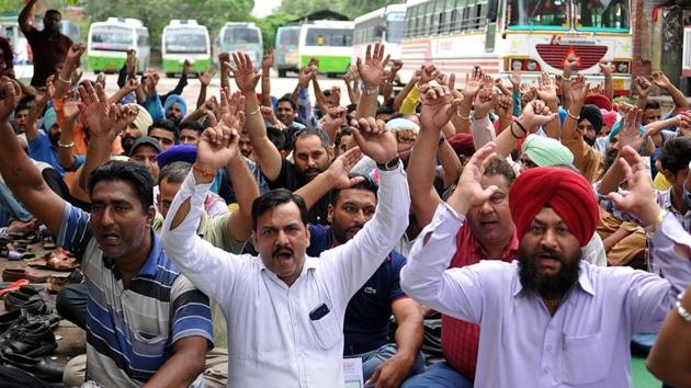 Members of the Punjab Roadways and Punbus Contract Workers Union holding a protest in Jalandhar on Monday.(HT Photo)