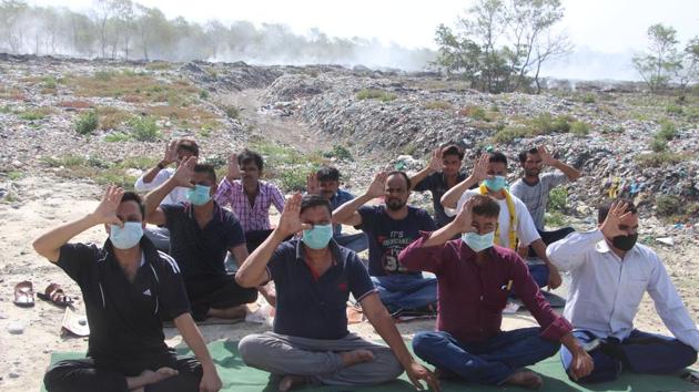 On the occasion of International Yoga Day on June 21, residents in Haldwani practised yoga at a trenching ground wearing masks to highlight their plight.(HT File Photo)