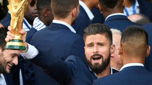 France's forward Olivier Giroud holds the trophy as he arrives with teammates for a reception at the Elysee Presidential Palace on July 16, 2018 in Paris, after French players won the 2018 FIFA World Cup final.(AFP)