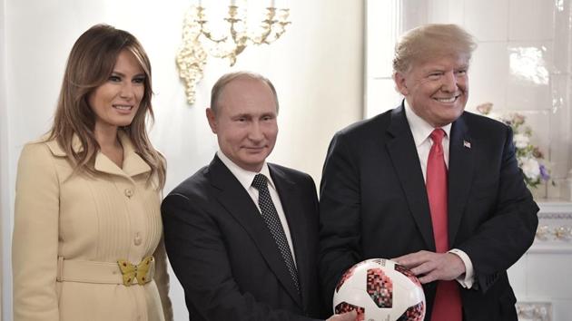 US First Lady Melania Trump, left, Russian President Vladimir Putin, centre, and US President Donald Trump pose with a football after a press conference following their meeting at the Presidential Palace in Helsinki, Finland, July 16 (AP)