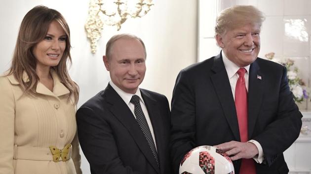 US First Lady Melania Trump, Russian President Vladimir Putin, and US President Donald Trump, pose with a soccer ball after a press conference following their meeting at the Presidential Palace in Helsinki, Finland.(AP File Photo)