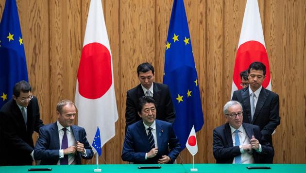 Japanese Prime Minister Shinzo Abe (C) signs an agreement with European Council President Donald Tusk (L) and European Commission President Jean-Claude Juncker (R) at the Prime Minister's Office in Tokyo.(AFP Photo)