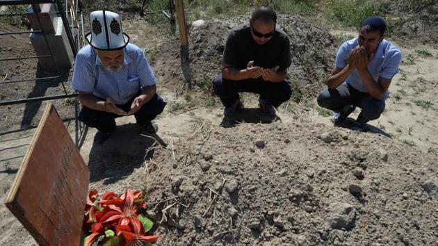 Relatives grieve by the Turdaaly’s grave. According to family members who saw her body, the 30-year-old suspect carved the young woman’s initial and that of her sweetheart into her chest, although police refute this. At least 23 police officers have been either disciplined, suspended or sacked for negligence after her suspected kidnapper allegedly stabbed her to death as she waited to give a witness statement against him. (Vyacheslav OSELEDKO / AFP) Relatives grieve by the Turdaaly’s grave. According to family members who saw her body, the 30-year-old suspect carved the young woman’s initial and that of her sweetheart into her chest, although police refute this. At least 23 police officers have been either disciplined, suspended or sacked for negligence after her suspected kidnapper allegedly stabbed her to death as she waited to give a witness statement against him. (Vyacheslav OSELEDKO / AFP)