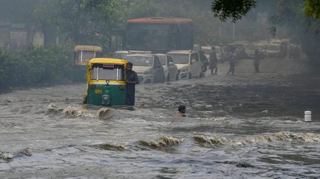 Vehicles wade across a waterlogged street after monsoon rain in New Delhi, on Monday. (PTI Photo) Vehicles wade across a waterlogged street after monsoon rain in New Delhi, on Monday. (PTI Photo)