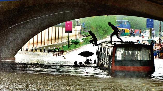 A bus is seen stranded under the Minto road bridge after heavy rainfall in New Delhi on Monday, July 16, 2018.(Sushil Kumar/ HT Photo)