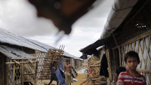 Refugees carry construction material through huts built in an extended area of Kutupalong camp where some refugees from areas at risk of landslides and flooding were relocated to. Children are receiving identity bracelets in case they are separated from parents in the flooding. Families have received extra materials to fortify shelters. Trenches have been dug to try and redirect floodwaters. (Wong Maye-E / AP) Refugees carry construction material through huts built in an extended area of Kutupalong camp where some refugees from areas at risk of landslides and flooding were relocated to. Children are receiving identity bracelets in case they are separated from parents in the flooding. Families have received extra materials to fortify shelters. Trenches have been dug to try and redirect floodwaters. (Wong Maye-E / AP)