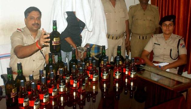RPF team of Dhanabd with the two arrested persons who were smuggling Indian Made Foreign Liquor via train to Bihar in Dhanbad. (HT File Photo)