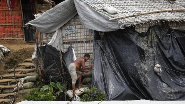 A man covers his shelter with waterproof tarp in Chakmarkul refugee camp. The most intense rains are expected over the next few months, though downpours began pummeling the camps in June. There have already been more than 160 landslides, 30 people injured and one toddler killed, according to the Inter Sector Coordination Group, or ISCG, which oversees aid agencies in the camps. (Wong Maye-E / AP) A man covers his shelter with waterproof tarp in Chakmarkul refugee camp. The most intense rains are expected over the next few months, though downpours began pummeling the camps in June. There have already been more than 160 landslides, 30 people injured and one toddler killed, according to the Inter Sector Coordination Group, or ISCG, which oversees aid agencies in the camps. (Wong Maye-E / AP)