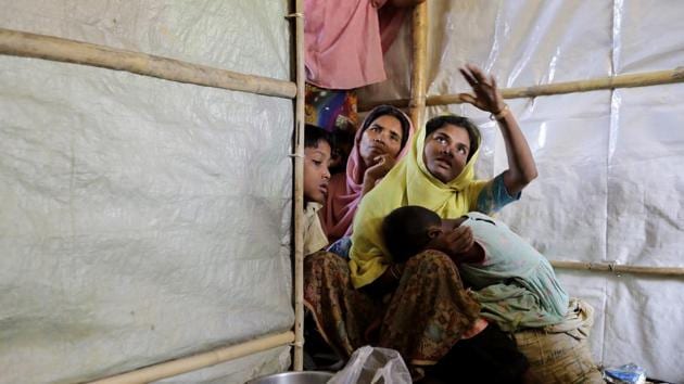 Mustawkima (C), sits in her relative's shelter as she talks about abandoning her previous shelters. Hers is a dilemma repeated over and over for many of the 900,000 Rohingya living in ramshackle huts across this unsteady landscape. As the rains begin to flood parts of the camps, many find themselves trapped — by geography, by poverty and by fear. (Wong Maye-E / AP) Mustawkima (C), sits in her relative's shelter as she talks about abandoning her previous shelters. Hers is a dilemma repeated over and over for many of the 900,000 Rohingya living in ramshackle huts across this unsteady landscape. As the rains begin to flood parts of the camps, many find themselves trapped — by geography, by poverty and by fear. (Wong Maye-E / AP)