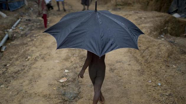 A Rohingya child refugee carries an umbrella as he walks through Kutupalong refugee camp. More than 200,000 people are living in areas considered at risk of landslides and flooding, according to the ISCG. Around 34,000 refugees have been relocated to other areas, with some moving into sturdier shelters further away from the hills. (Wong Maye-E / AP) A Rohingya child refugee carries an umbrella as he walks through Kutupalong refugee camp. More than 200,000 people are living in areas considered at risk of landslides and flooding, according to the ISCG. Around 34,000 refugees have been relocated to other areas, with some moving into sturdier shelters further away from the hills. (Wong Maye-E / AP)