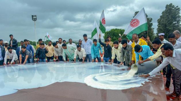 Swabhimani Shetkari Sanghatana activists pour milk at the memorial of Maharashtra's first Chief Minister late Y B Chavan during a protest to demand subsidy per liter and waiver of GST for butter and milk powder, in Karad on Monday.(HT Photo)