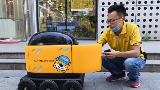 A worker loads a delivery robot with groceries. China is the world’s biggest online shopping market with more than half of its population making at least one smartphone purchase per month, according to professional services firm PricewaterhouseCoopers. This compares to 14% in the rest of the world. (Greg Baker / AFP) A worker loads a delivery robot with groceries. China is the world’s biggest online shopping market with more than half of its population making at least one smartphone purchase per month, according to professional services firm PricewaterhouseCoopers. This compares to 14% in the rest of the world. (Greg Baker / AFP)
