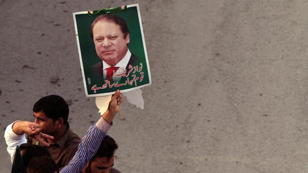 A supporter of the Pakistan Muslim League - Nawaz (PML-N) holds a portrait as he march towards the airport with others to see ousted prime pinister Nawaz Sharif and his daughter Maryam, in Lahore.(Reuters File Photo)