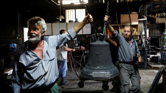 Thomas (L), 59, and Christos Galanopoulos, 55, prepare to clean a bell covered with sand. The Galanopoulos’s biggest bell, weighing 3.5 tonnes, hangs from a church in northern Greece. But those days are gone. The volatile commodities market made the bells too costly to produce at times. Six people now work in the foundry, down from nine. (Alkis Konstantinidis / REUTERS)