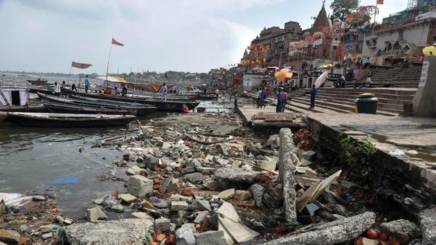 People stand near the dried out Assi Ghat of the Ganga river in Varanasi on June 28.(PTI Photo)