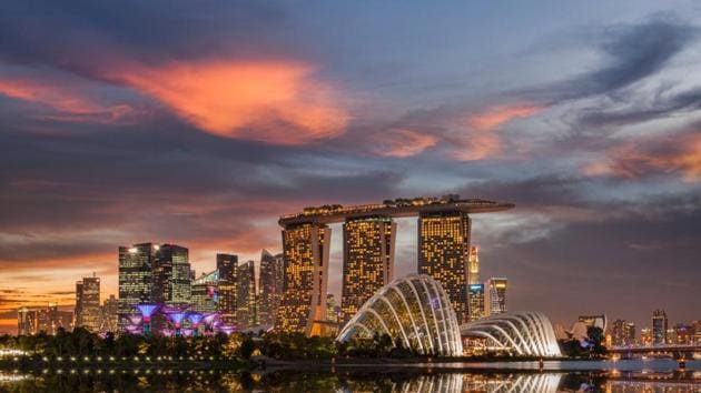 Sunset with the backdrop of the Singapore skyline, with Marina Bay Sands and the Gardens on the Bay reflecting in Marina Bay. (shutterstock) 