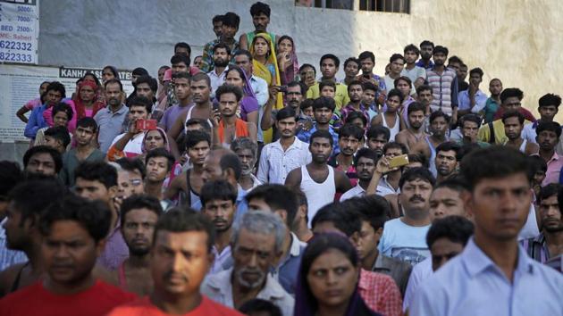 People watch rescuers work at the site of a building collapse in Shahberi village, east of New Delhi on July 18, 2018. The six-story building under construction collapsed onto an adjacent building. (Altaf Qadri / AP)