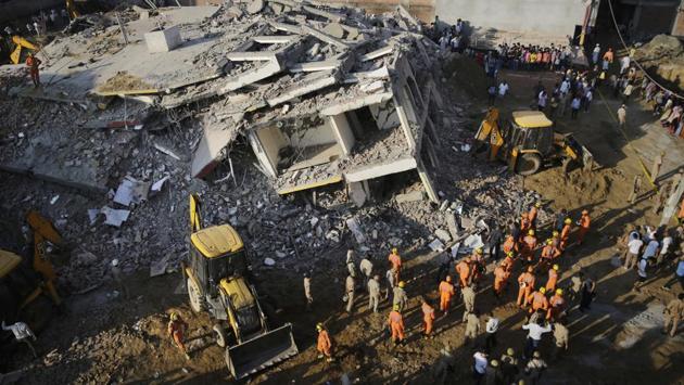 NDRF rescue workers search the debris for people buried underneath at the site of a building collapse in Shahberi village, east of New Delhi on July 18, 2018. (Altaf Qadri / AP)