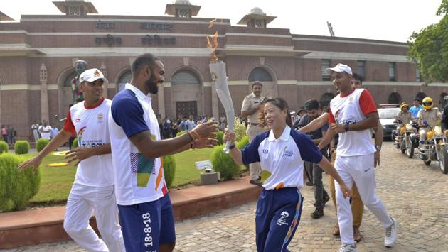 Indian men's hockey team captain P.R. Sreejesh (L), prepares to receive the Asian Games torch from Indian boxer Mary Kom during the beginning of the torch relay at the Major Dhyanchand National Stadium, in New Delhi on July 15, 2018. The 18th Asian Games was scheduled to begin in Jakarta on August 18. (Prem Singh / AP)