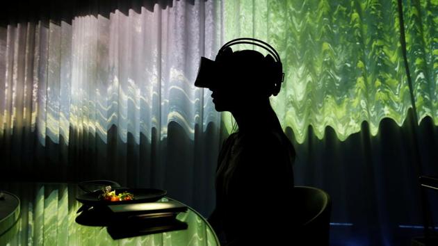 A woman wears VR glasses while projection mapping is cast on a table and walls during a media preview at "Tree by Naked, Yoyogi Park" restaurant in Tokyo, Japan. This restaurant incorporates virtual reality, projection mapping, and music to enhance diners’ enjoyment of their food. (Kim Kyung-Hoon / REUTERS) A woman wears VR glasses while projection mapping is cast on a table and walls during a media preview at "Tree by Naked, Yoyogi Park" restaurant in Tokyo, Japan. This restaurant incorporates virtual reality, projection mapping, and music to enhance diners’ enjoyment of their food. (Kim Kyung-Hoon / REUTERS)