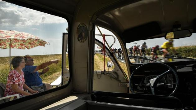 As seen from a spectators’ car on the side of the route, a fan (L) points to Belgium’s Greg Van Avermaet (R), wearing the overall leader’s yellow jersey, cycling past during the seventh stage on July 13, 2018. (Marco Bertorello / AFP) As seen from a spectators’ car on the side of the route, a fan (L) points to Belgium’s Greg Van Avermaet (R), wearing the overall leader’s yellow jersey, cycling past during the seventh stage on July 13, 2018. (Marco Bertorello / AFP)