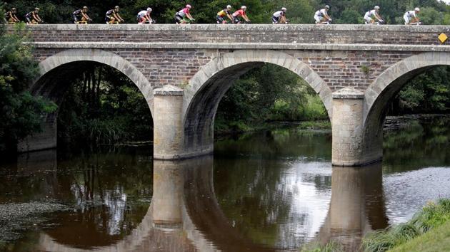 Cyclists race past a bridge during stage 4 from La Baule to Sarzeau on July 10, 2018. (Stephane Mahe / REUTERS) Cyclists race past a bridge during stage 4 from La Baule to Sarzeau on July 10, 2018. (Stephane Mahe / REUTERS)