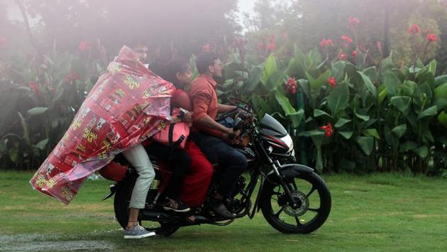 People ride a motorcycle as it rains near India Gate lawns in New Delhi on July 16, 2018. (Shivam Saxena / HT Photo)