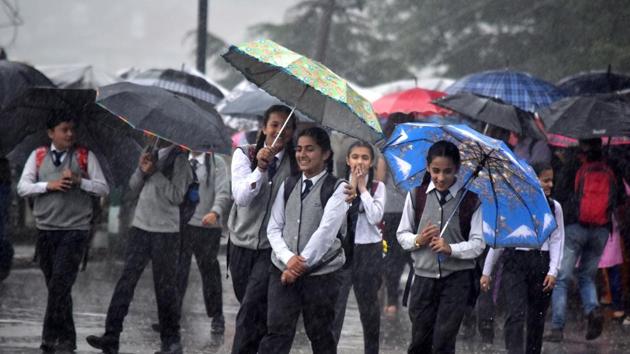 Schoolchildren use umbrellas to protect themselves from the rain at Ridge, Shimla on July 18, 2018. (Deepak Sansta / HT Photo)