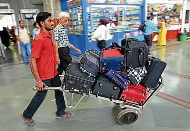 Currently, porters carry luggage on plank-like trolleys (above), but the new ones will resemble those used at airports.(HT File Photo)