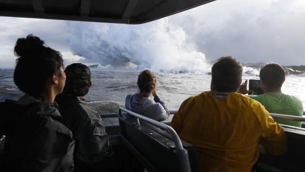 People watch a plume of steam as lava enters the ocean. One explosion sent lava flying through the roof of a tour boat off Big Island, injuring at least 13 people. Diane Ley, Hawaii County’s director of research and development, said she’s been working on setting up a lava viewing site for nearly two months. The injuries from the tour boat only validate the county’s caution, she said. (Jae C. Hong / AP) People watch a plume of steam as lava enters the ocean. One explosion sent lava flying through the roof of a tour boat off Big Island, injuring at least 13 people. Diane Ley, Hawaii County’s director of research and development, said she’s been working on setting up a lava viewing site for nearly two months. The injuries from the tour boat only validate the county’s caution, she said. (Jae C. Hong / AP)