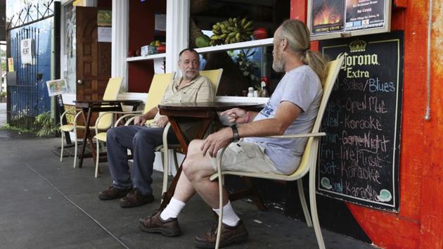 Brothers Ed (L), and Mike Arends, who evacuated their homes in the Leilani Estates area sit outside Pele’s Kitchen restaurant in Pahoa. Restaurants and shops in Pahoa have lost 50 to 90% of their business, said Matthew Purvis, president of the Mainstreet Pahoa Association. This is partly because many residents have lost their homes and moved, but a significant chunk is because fewer tourists are visiting. (Caleb Jones / AP File) Brothers Ed (L), and Mike Arends, who evacuated their homes in the Leilani Estates area sit outside Pele’s Kitchen restaurant in Pahoa. Restaurants and shops in Pahoa have lost 50 to 90% of their business, said Matthew Purvis, president of the Mainstreet Pahoa Association. This is partly because many residents have lost their homes and moved, but a significant chunk is because fewer tourists are visiting. (Caleb Jones / AP File)