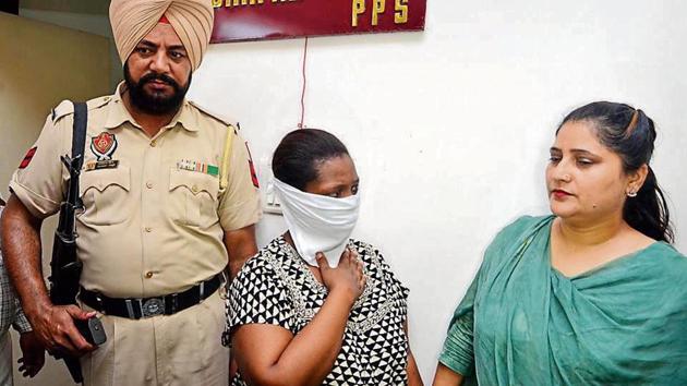 Ugandan national Rubia (centre) arrested from Delhi in Punjab Police custody in Amritsar on Saturday. After her interrogation, cops recovered 1kg heroin buried near Patti in Tarn Taran.(HT Photo)