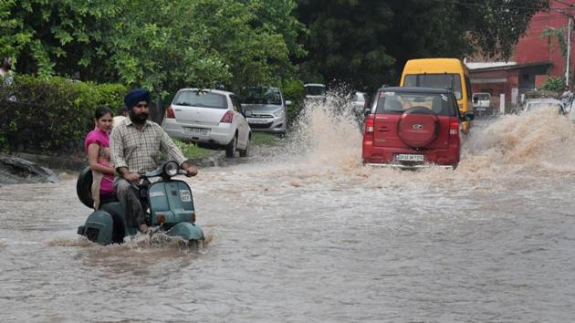 Commuters manoeuvring through a waterlogged street in Chandigarh. (HT Photo) Commuters manoeuvring through a waterlogged street in Chandigarh. (HT Photo)