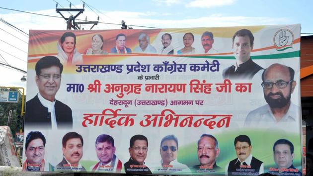 A hoarding erected at Rajiv Bhawan in Dehradun on Monday did not have former CM Harish Rawat's photo. (Vinay Santosh Kumar /HT)
