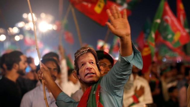 A supporter of Imran Khan, chairman of the Pakistan Tehreek-e-Insaf (PTI), political party, wears a mask and dance on party songs during a campaign rally ahead of general elections in Karachi, Pakistan.(REUTERS File Photo)