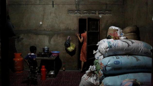 Touch stands at the door of her house as her son looks on. It gets dark when she returns home to cook the evening meal and wait for her husband, who is a temporary construction worker. (Ann Wang / REUTERS) Touch stands at the door of her house as her son looks on. It gets dark when she returns home to cook the evening meal and wait for her husband, who is a temporary construction worker. (Ann Wang / REUTERS)