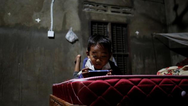 Seng Tharith, 4, the son of Touch, plays with a cellphone in his house. Touch was determined her children will have a better life, whatever the election outcome may be. “I want my children to have a good education, not to be like me and my husband,” she said. (Ann Wang / REUTERS) Seng Tharith, 4, the son of Touch, plays with a cellphone in his house. Touch was determined her children will have a better life, whatever the election outcome may be. “I want my children to have a good education, not to be like me and my husband,” she said. (Ann Wang / REUTERS)