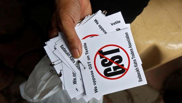 A cloth merchant holds message papers to distribute as he attends a procession during a strike to protest the implementation of the Goods and Services Tax (GST) on textiles in Kolkata on June 30,2017. (Reuters File) A cloth merchant holds message papers to distribute as he attends a procession during a strike to protest the implementation of the Goods and Services Tax (GST) on textiles in Kolkata on June 30,2017. (Reuters File)