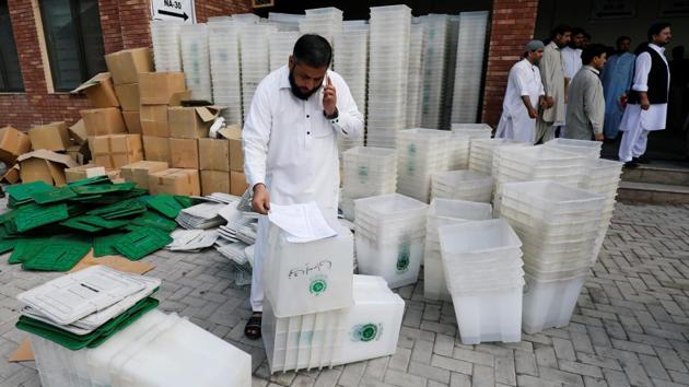 A man goes through a list of materials for distribution among electoral workers, ahead of general election in Peshawar, Pakistan, on Tuesday.(Reuters photo)