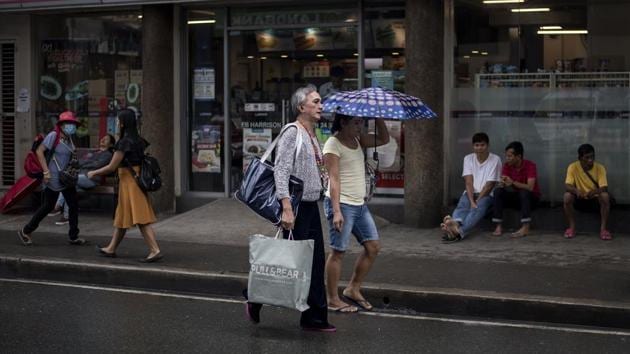 Federico Ramasamy, 60, also known as ‘Rikka’, and Gretchen walk on a street to participate in the beauty pageant. Due to nation’s weak social safety, the Golden Gays have recruited corporate and private sponsors who pay for their members to get a decent lunch and a few days’ worth of groceries after the pageants they hold at least once a month. (Noel Celis / AFP) Federico Ramasamy, 60, also known as ‘Rikka’, and Gretchen walk on a street to participate in the beauty pageant. Due to nation’s weak social safety, the Golden Gays have recruited corporate and private sponsors who pay for their members to get a decent lunch and a few days’ worth of groceries after the pageants they hold at least once a month. (Noel Celis / AFP)