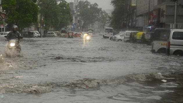 Vehicles pass through waterlogged MI Road in Jaipur during rains on Tuesday.(HT Photo)