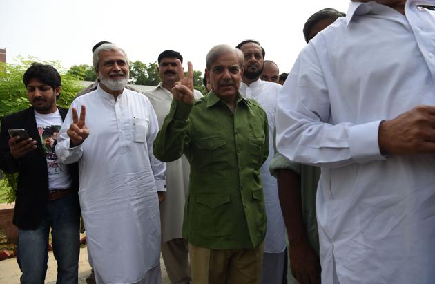 Shabaz Sharif (C), the younger brother of ousted Pakistani Prime Minister Nawaz Sharif and the head of Pakistan Muslim League-Nawaz (PML-N), stands in a queue before casting his vote during Pakistan's general election at a polling station in Lahore on July 25, 2018.(AFP Photo)