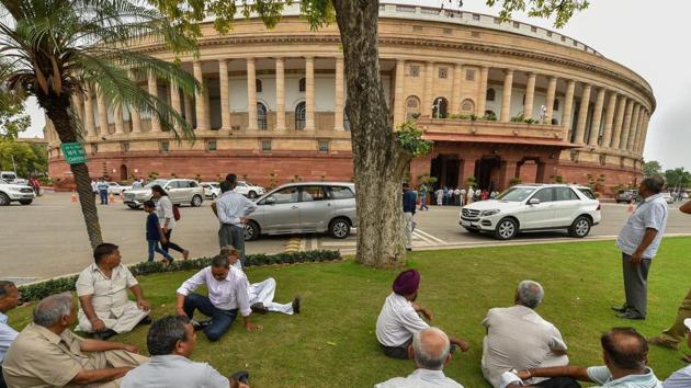 Visitors sit near Parliament House during the Monsoon session in New Delhi. (PTI File Photo) Visitors sit near Parliament House during the Monsoon session in New Delhi. (PTI File Photo)