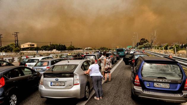 Cars were blocked at the closed National Road during a wildfire in Kineta. The Greek media described the disaster as a “national tragedy”, while Prime Minister Alexis Tsipras cut short a visit to Bosnia and announced three days of national mourning. (Valerie Gache / AFP) Cars were blocked at the closed National Road during a wildfire in Kineta. The Greek media described the disaster as a “national tragedy”, while Prime Minister Alexis Tsipras cut short a visit to Bosnia and announced three days of national mourning. (Valerie Gache / AFP)